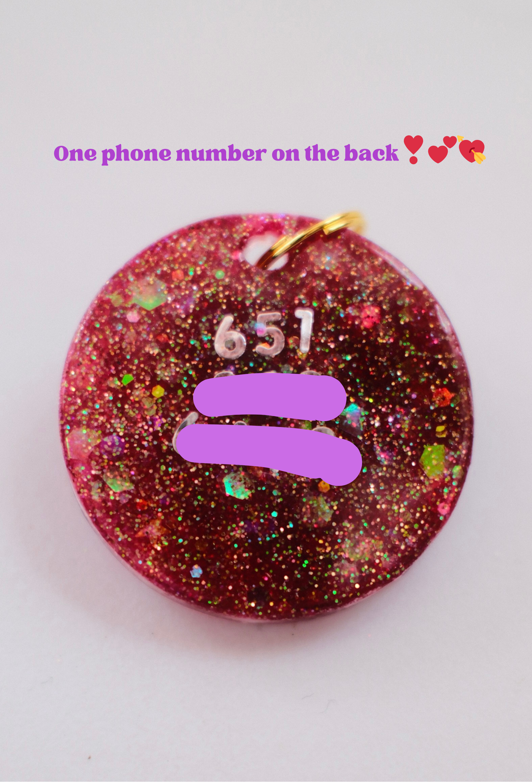 Circle-shaped pink and red Valentine-themed pet ID tag decorated with heart-shaped letter beads spelling the pet’s name and a 3D purple bow charm - a phone number is listed on the back