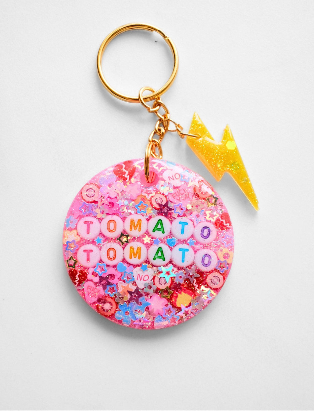 Keychain with 'Tomato Tomato' text on a pink background
