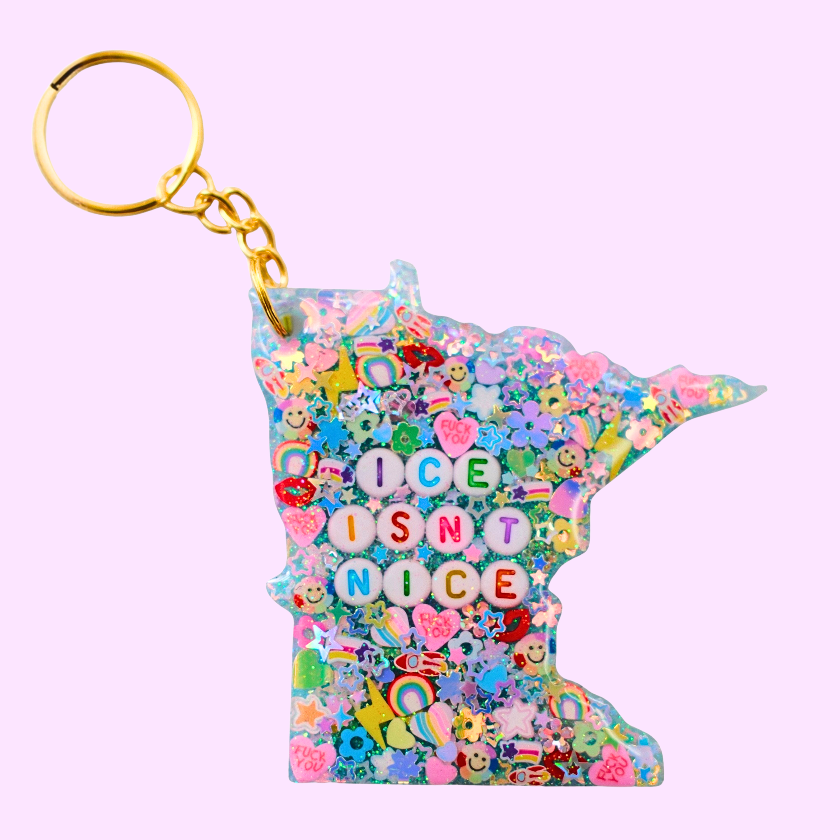 Keychain shaped like Minnesota with colorful design and 'ICE ISN'T NICE' text on a pink background
