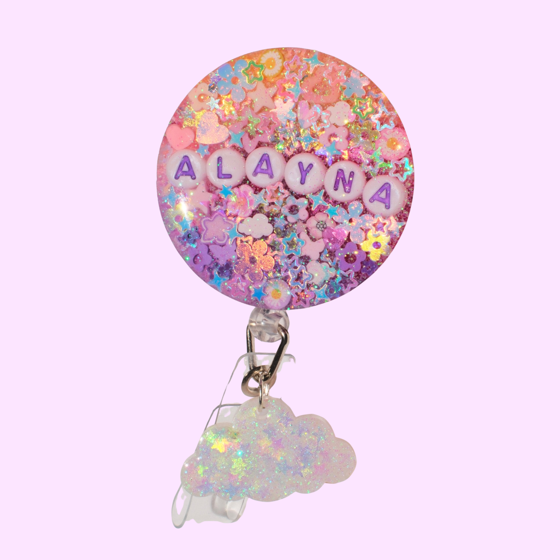 Colorful badge reel with 'ALAYNA' on a pink background and a cloud charm
